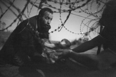 ZDJĘCIE ROKU - Warren Richardson: "Nadzieja na nowe życie - Mężczyzna podaje swoje dziecko przez płot na granicy węgiersko-serbskiej w Röszke."